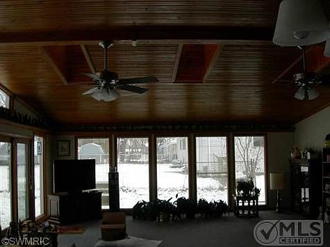VIEW OF FAMILY ROOM SHOWING WOOD CEILING AND THREE SKYLIGHTS AND VOLUME CEILNG