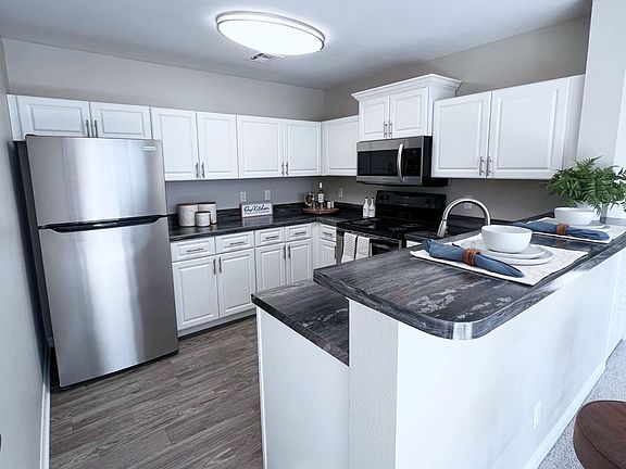 Upgrade your cooking space with chic white cabinetry and black fusion countertops.