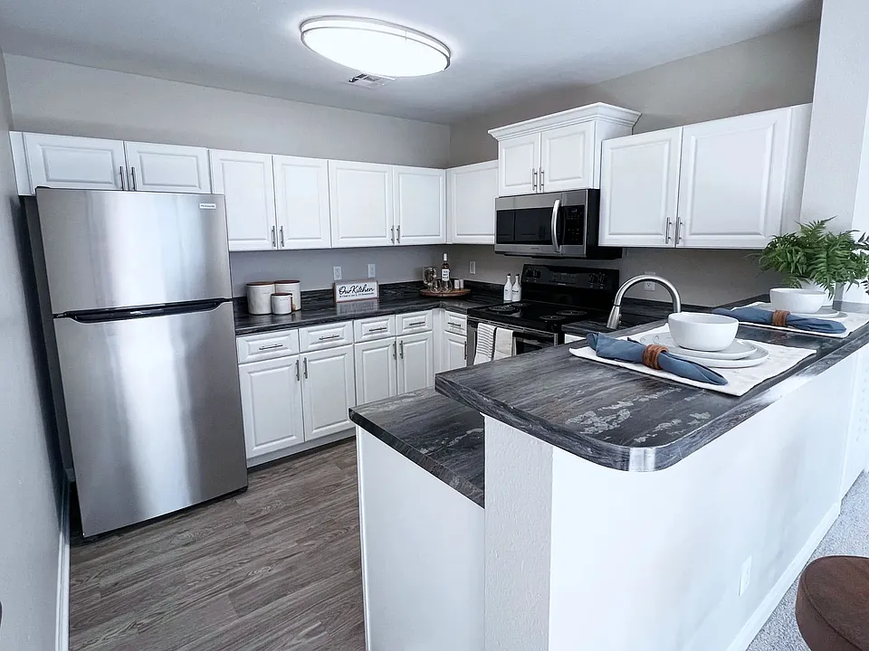 Upgrade your cooking space with chic white cabinetry and black fusion countertops.