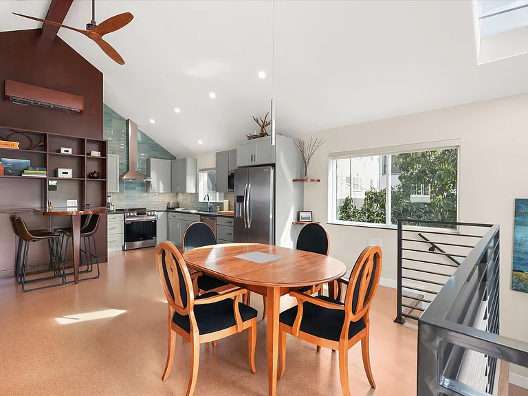 Open living and dining area with vaulted ceilings and abundant natural light.