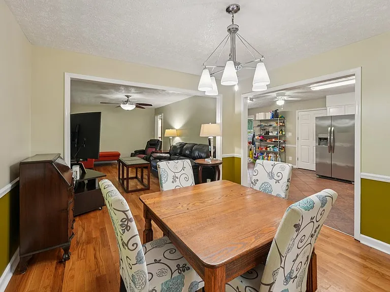 A bright and lovely dining room where polished wood floors, playful color, and backyard views come together for cozy dinners and enchanted mornings.