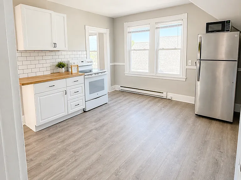 Refreshed kitchen with new fixtures, cabinets, subway tile backsplash.