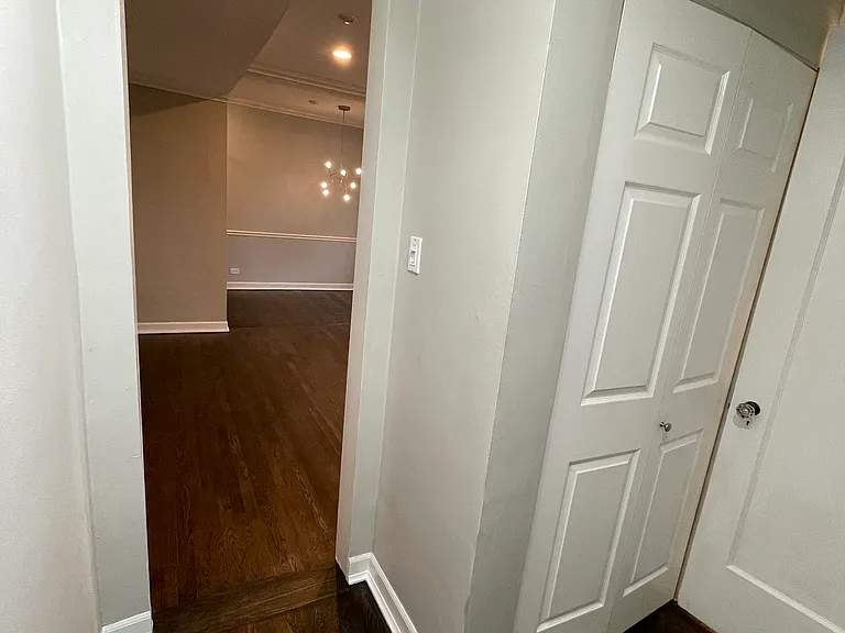 Hallway view from bedroom to living room (forward) and bathroom (right)
