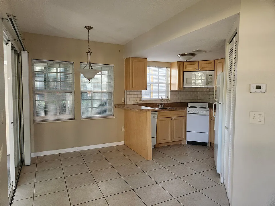 Dining room open to kitchen, lots of light with windows and slider leading to porch