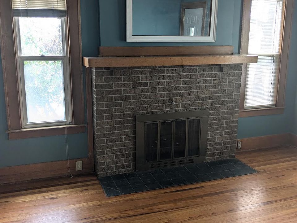 Living Room with non working fireplace looking from formal Dining Room arch