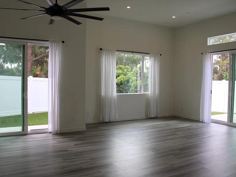 (Curtains not included)As this picture was taken from kitchen looking at living area and dining area. 
There are two large sliders leading out to the back yard with windows.