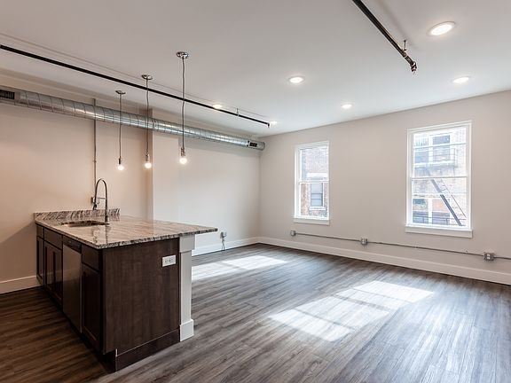 Unstaged photo shows off luxury vinyl plank floors for easy care. Cool fixtures.