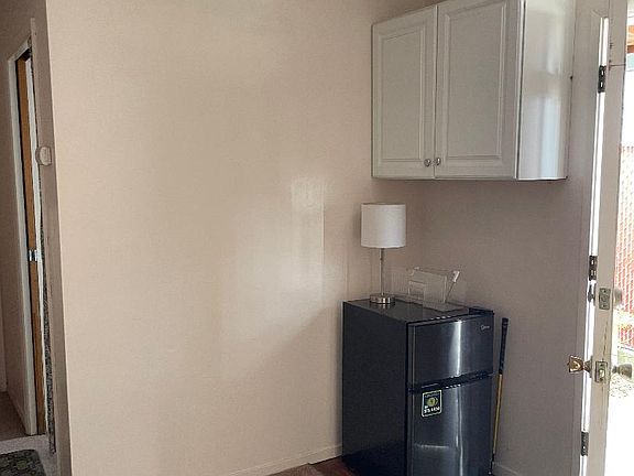 included small fridge and notice cabinet above for storage.