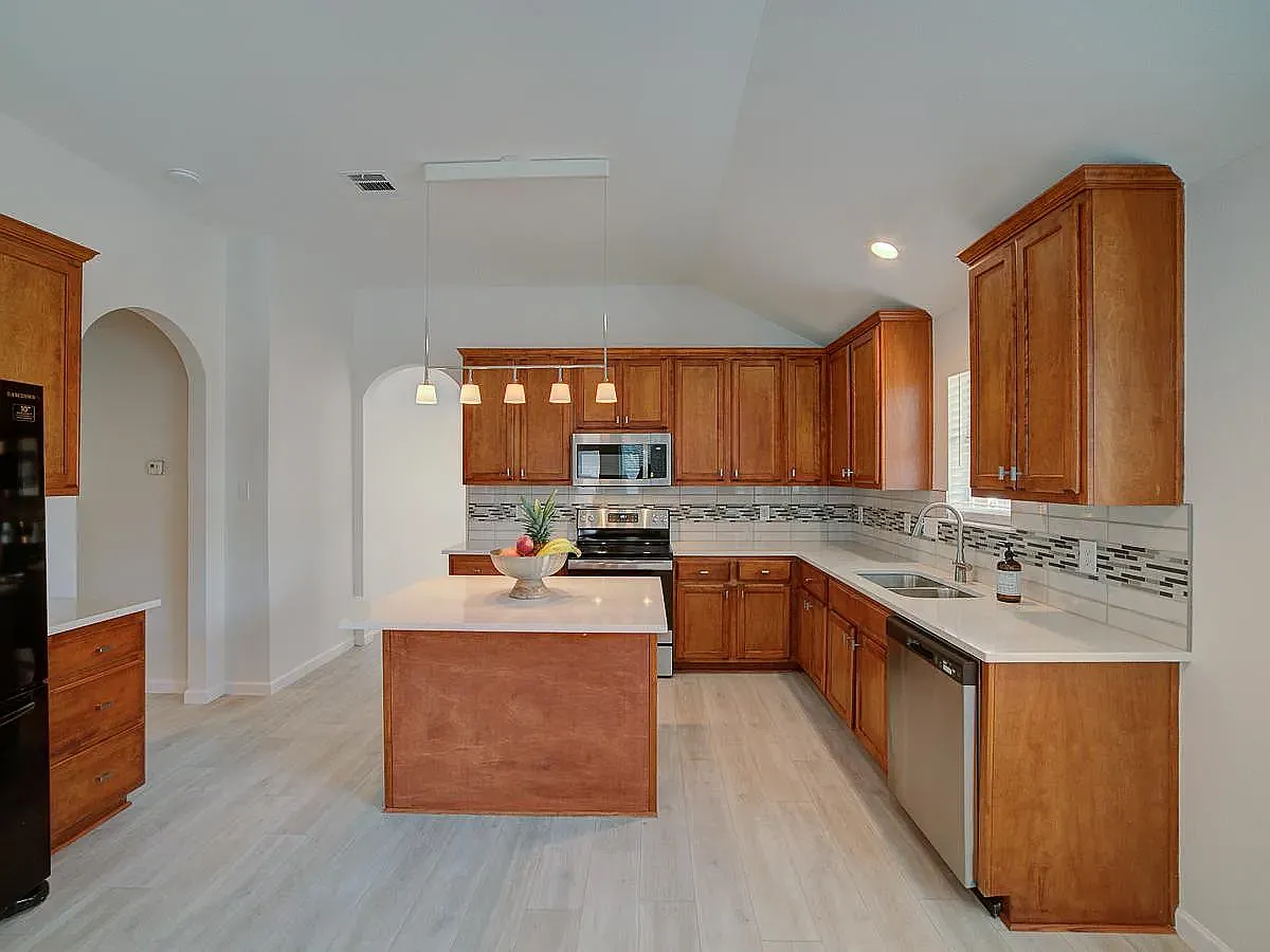 HUGE chef's kitchen, with quartz countertops, modern elegant backsplash, stainless steel appliances and a prep island - 1016 Zeus Cir