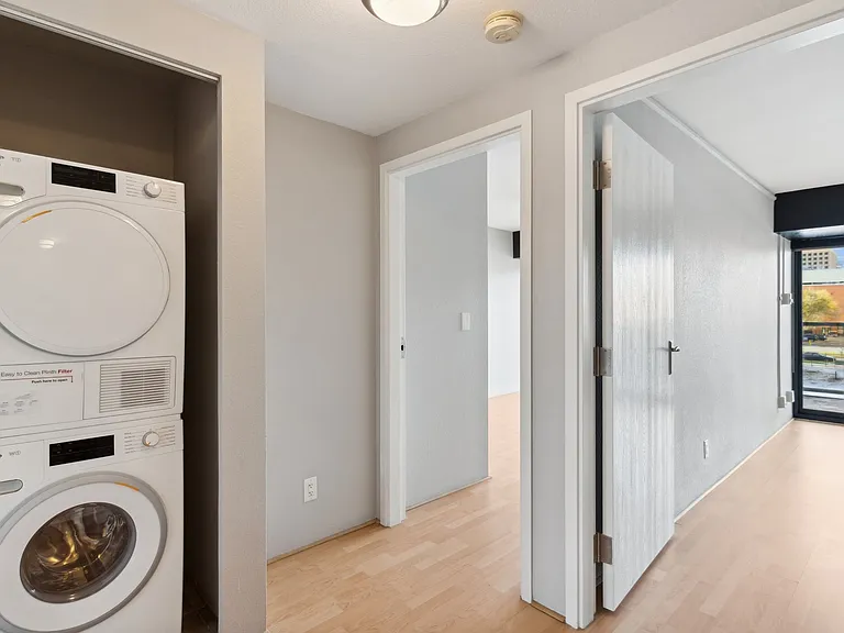 Hallway with washer + dryer and doors to both bedrooms