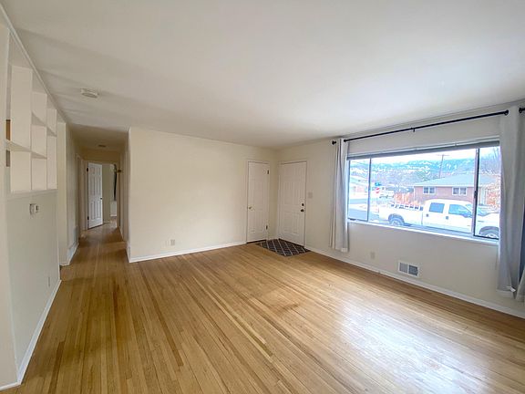 Oak floors and an open living room area next to a large picture window with Flatiron views
