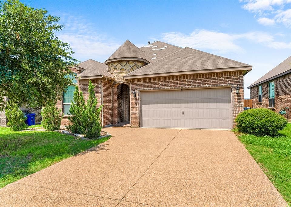 View of front facade featuring brick siding, a shingled roof, a garage, concrete driveway, and a front yard