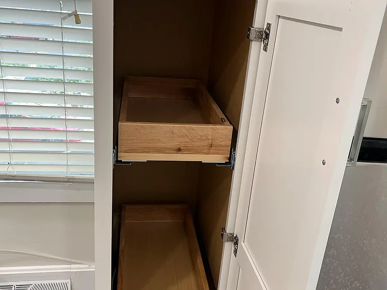 Cabinet next to the refrigerator with pull out drawers
