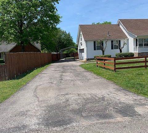 Driveway with fence to keep kids in the back yard.