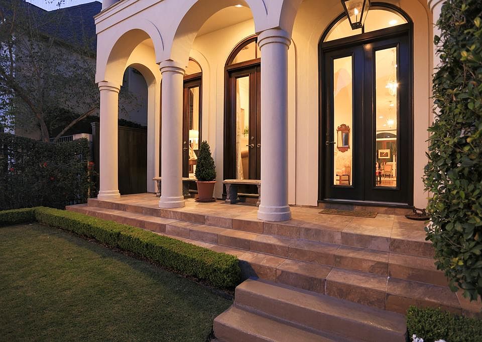 FRONT YARD-Tiled steps lead to this portico styled front porch with a custom over sized mahogany front door and 2 sets of 8' French doors. A large gas lamp lights the way. Manicured lawn with roses are enclosed by an ornamental wrought iron fence.