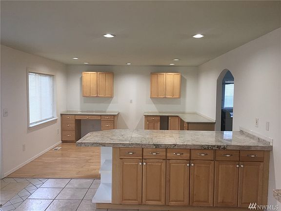 Dining area adjacent to kitchen with eating bar and French doors leading to covered deck and backyard.