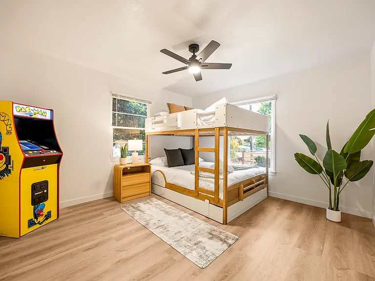 Fun and family-friendly bunk room featuring a queen-over-queen bunk bed, twin trundle, arcade game, and plenty of space for kids to unwind and enjoy.