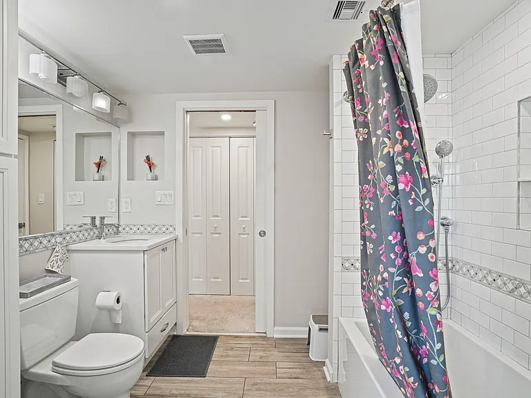 Expansive, well-appointed bathroom featuring a full-size soaking tub, modern vanity, and crisp, clean finishes