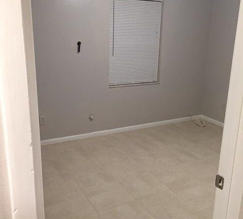 Living room with new paint and tile through out apt.