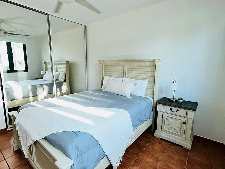 Bedroom 2 with ceiling fan, A/C system, blinds, closet, nightstand, bedside lamp, and a private bathroom