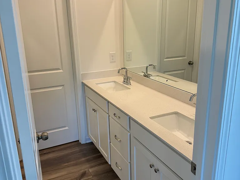Main bedroom bathroom with double vanity, shower and separate room for toilet