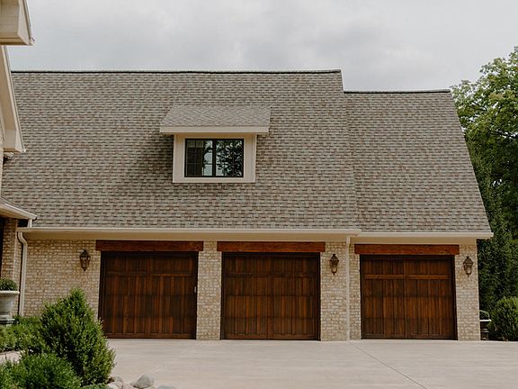 3 carriage doors and a windowed dormer create such a pretty facade for the 3-stall garage.  Mahogany