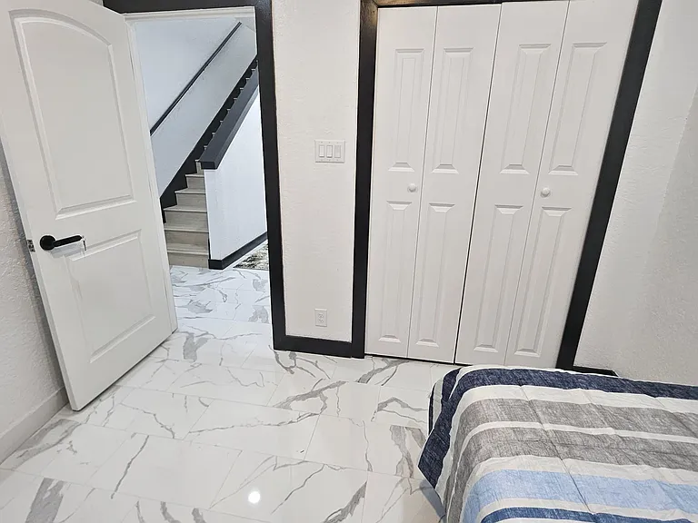 Bedroom features a double-door closet for storage, with easy access to the hallway and stairs.