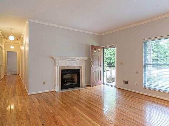 Living Room, front door, fireplace. Note: A TV mount over the fireplace has been installed along with HDMI wiring. Hardwood floors continue down hall to bedrooms, baths, and laundry closet.