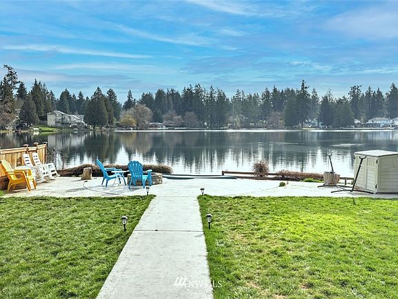 Fully fenced yard with concrete walkway to the water