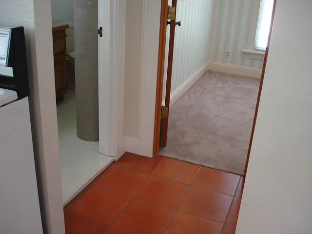 Hallway from Kitchen to bathroom, door on the right and back bedroom straight ahead,