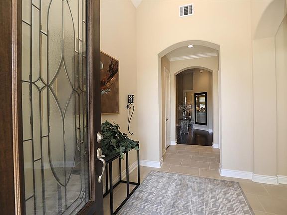 Foyer offers rounded sheet rock at 90 degree corners and 8" doors. Neutral paint and crown molding. Rocker panel light switches and upgraded "brick lay"ceramic tile flooring. Security system and Taexx built in pest control system.