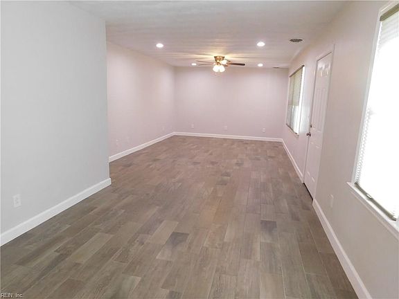 View from the kitchen back toward the far wall. Front door is at right. Honeycombe blinds by Hunter Douglas throughout. 