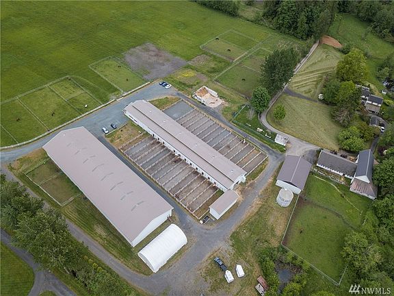 Covered arena, barns, outbuildings, silo and farmhouse.