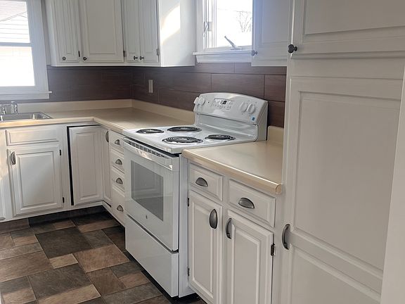 Kitchen has brand new range, flooring, & refrigerator.