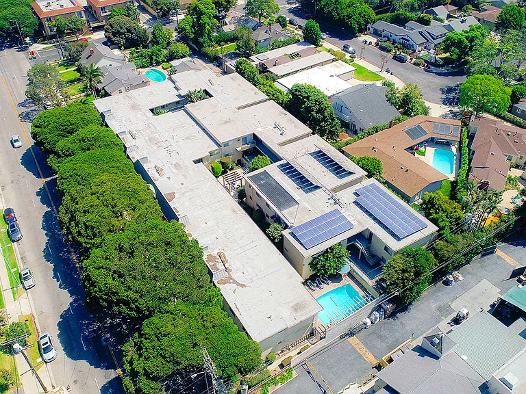 Aerial drone view of National Apartments depicting roof-mounted solar panels and adjacency to Whole Foods Market.