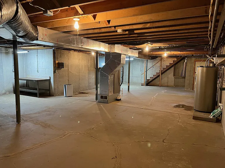 Basement view back toward stairs
Workbench on left
Modern water heater and other utilities, on the left. Includes whole house filter & water softener, water pump system pressure tank etc. 
New high efficiency heat pump / AC (16 SEER), January, 2022