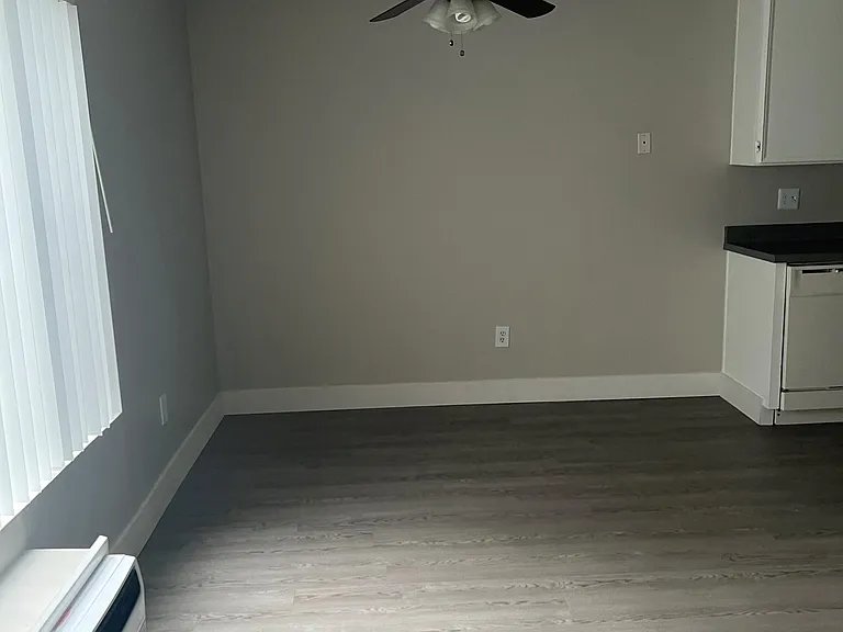 Dining area with ceiling fan and plank style flooring at IKARIA Apartments in Santee, California.