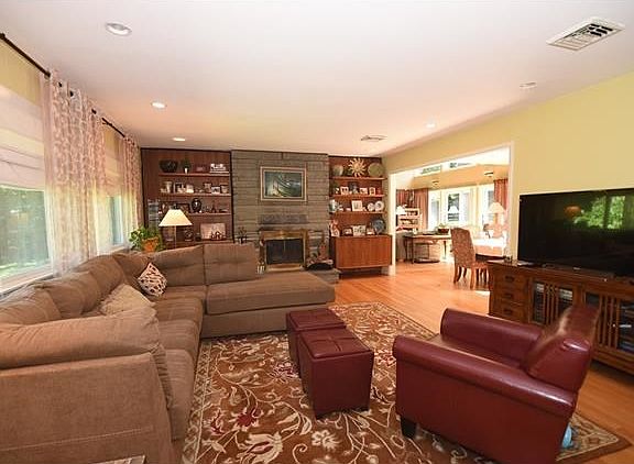 Spacious and bright living room with hardwood floors and floor to ceiling fireplace