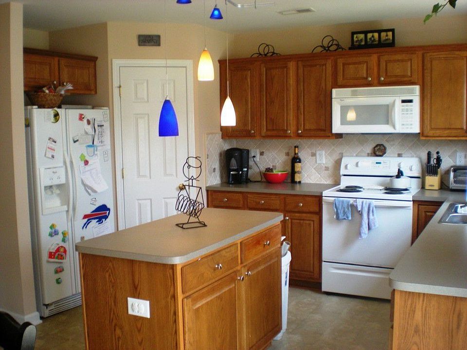 Kitchen with island, pantry, and stone tile backsplash.  All Appliances!