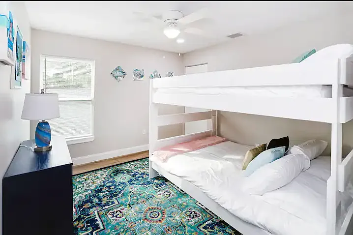 Vibrant bunk bedroom with two queen beds, perfect for kids or extra guests, complete with colorful, fun decor.