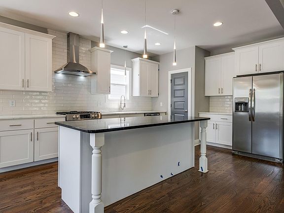 Kitchen with gas range, coffee bar, and island. Walk in pantry in the corner.