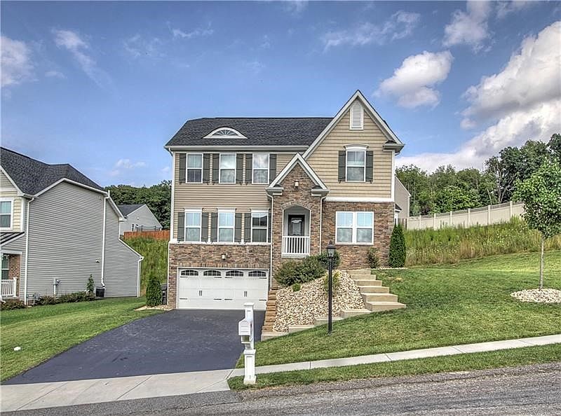 Curb Appeal Plus! This stone front features carriage style Tuscany garage doors, stone & covered entry & cedar style siding comp