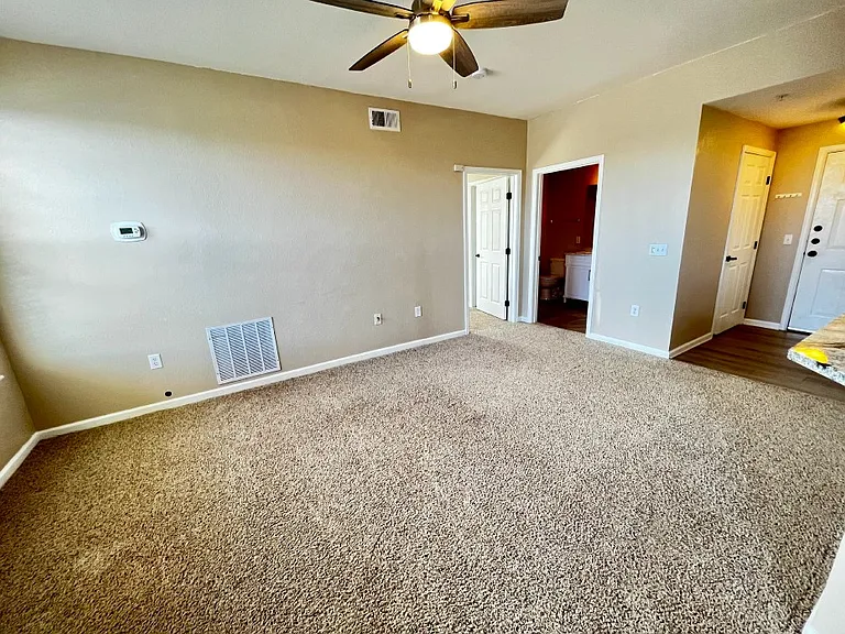 Living room looking at the entrance (right) and second bedroom (left) with ensuite bathroom.