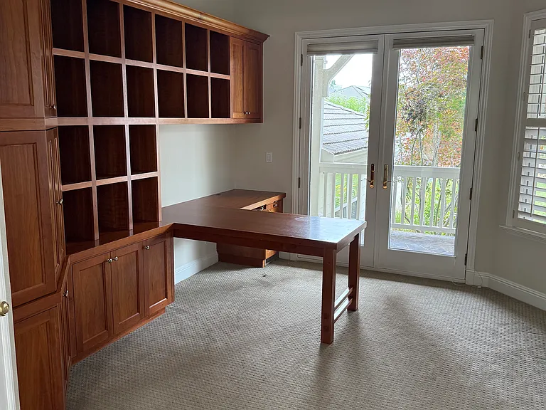 Home office with built-in shelves and front porch access through french doors