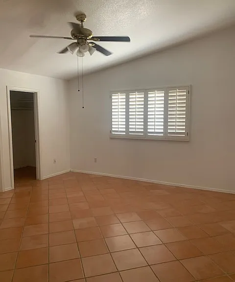 Master bedroom has walk in closet, attached bathroom, ceiling fan and plantation shutters
