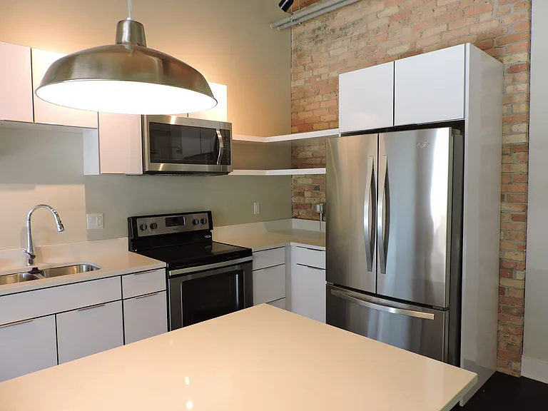 Kitchen of #203 - Front door located to the right of the fridge.