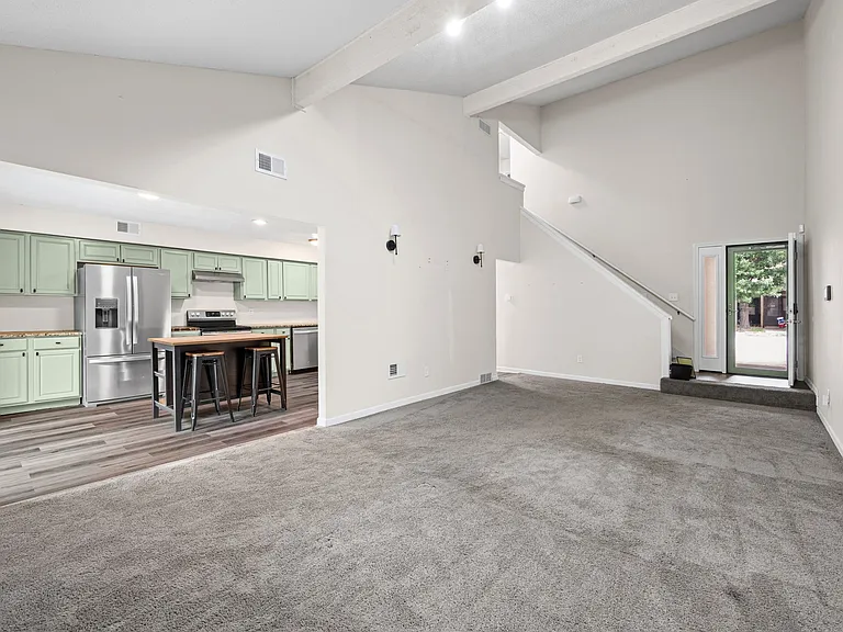 Living room and kitchen with view of stairs and front door