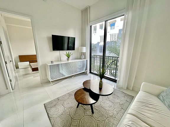 Living Room space fully furnished with mounted smart Tv