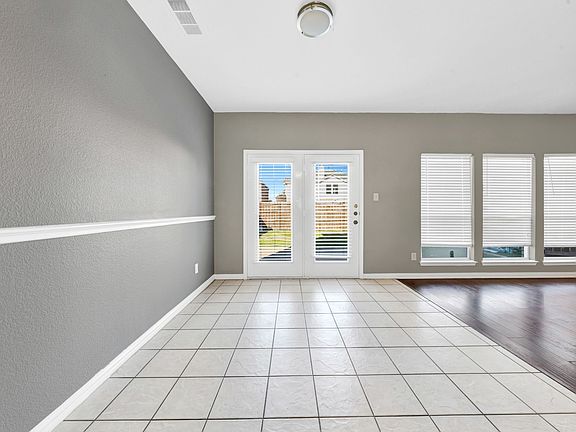 This tiled dining area sits between the kitchen and living room, offering an open floorplan that makes it easy to stay connected with family. Two full-height windows/door let in plenty of natural light and provide direct access to the backyard. The easy-t