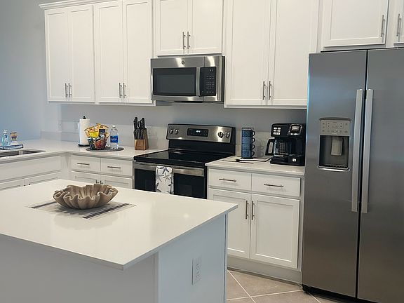Kitchen with well stocked dishes, glasses, utensils